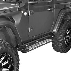 the front end of a black jeep with large wheels and tires on it's sides