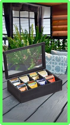 an open box on a wooden table with plants in the background