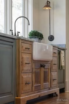 a kitchen with an island and sink in the middle of it, surrounded by windows