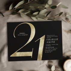 an elegant black and gold 21st birthday party with greenery on the side, including eucalyptus leaves