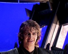 the young man is posing for a photo in front of a blue screen with his hand on his hip