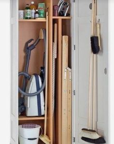 an open closet with cleaning supplies and brooms