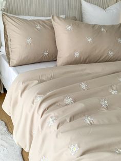 a bed with two pillows on top of it and one pillow has snowflakes on it