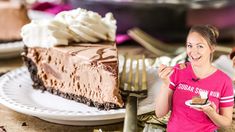 a woman holding a plate with a slice of cake on it and another pie in the background