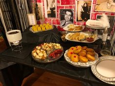 a table topped with plates and trays of food