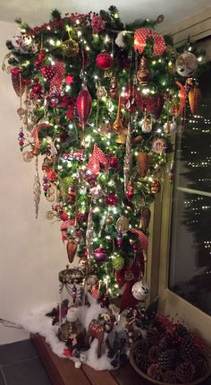 a christmas tree with ornaments hanging from it's sides and lights on the top