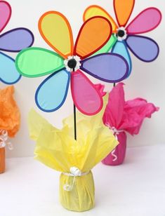 colorful paper flowers in vases with tissue bags