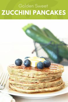 a stack of pancakes topped with blueberries and butter