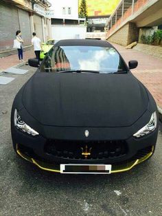 a black masera is parked on the street