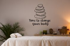 a bedroom with a bed and a wall sticker that says time to change your body