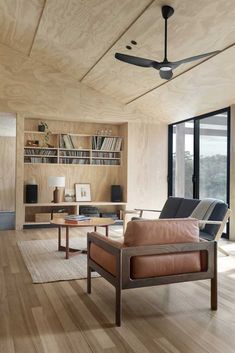 a living room filled with furniture and a ceiling fan in the middle of it's walls