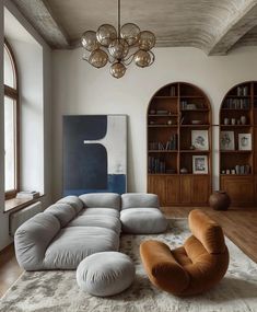 a living room filled with lots of furniture and bookshelves on top of a hard wood floor