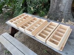 several wooden drawers sitting on top of a picnic table next to a tree and bench