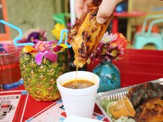 a person dipping some food into a cup