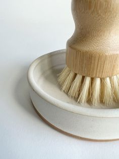 a wooden brush sitting on top of a white plate