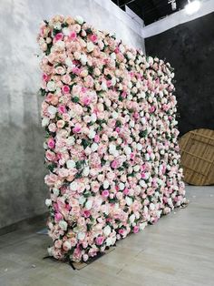 there is a large display of flowers on the wall in this room that has been decorated with pink and white roses