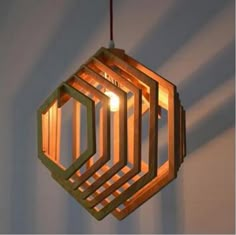 a wooden light fixture hanging from a ceiling in the shape of hexagons