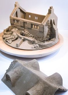 a model of a house on top of a table with a paper roll laying next to it