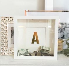 a framed letter and some money are on a table next to two frames with letters