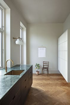 a kitchen with wooden floors and white walls