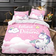 a pink bed with unicorns and clouds on it