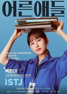 a woman holding up a stack of books on top of her head in front of a blue background