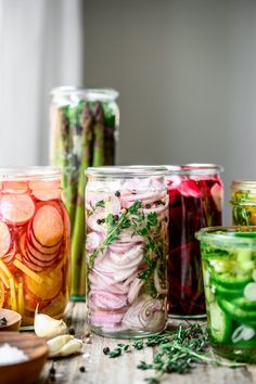 several jars filled with different types of vegetables