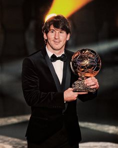 a man in a tuxedo holding an award