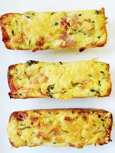 three pieces of bread with cheese and vegetables on them sitting next to each other in front of a white background