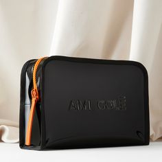 A shiny jet-black bag designed to carry all of your Ami Colé favorites and more. "Other bags I've tried either weren't chic enough to double as a day bag, or weren't durable enough to actually function as toiletry cases. Our bag does both beautifully!" —Diarrha, Founder & CEO This item is final sale. Luxury Black Rectangular Cosmetic Bag, Black Rectangular Pouch Gift Case, Black Rectangular Pouch For Gifts, Black Rectangular Pouch As Gift, Black Glossy Travel Bags, Rectangular Black Pouch For Gift, Luxury Black Cosmetic Bag With Removable Pouch, Functional Black Bag With Case Included, Rectangular Black Cosmetic Bag Gift