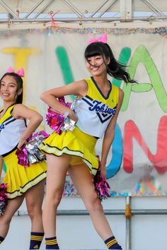 two girls in cheerleader outfits on stage