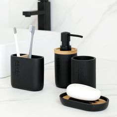 black bathroom accessories with toothbrush and soap dispenser