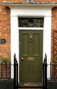 a green front door on a brick building