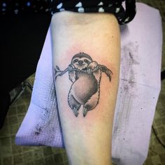 a small black and white penguin tattoo on the arm