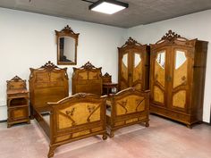 a room with wooden furniture and mirrors on the walls, including an antique bed frame