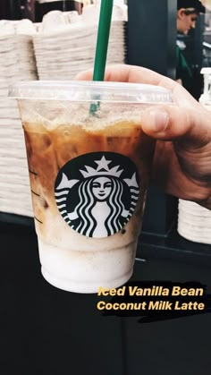 a person holding up a starbucks drink in their hand