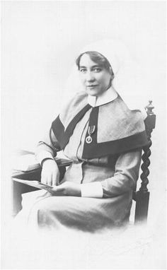 an old black and white photo of a woman in a nun outfit sitting on a chair