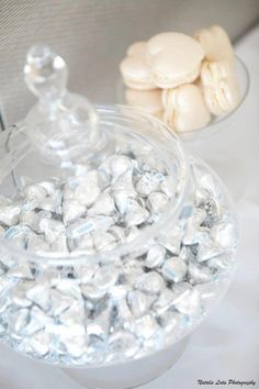 two bowls filled with white and silver candies on top of a table next to each other