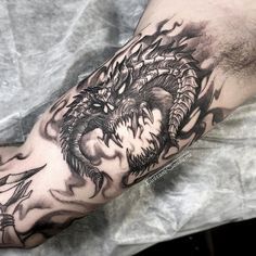 a man's arm with a dragon tattoo on it