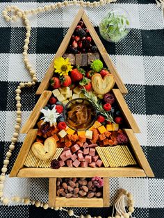 a wooden tray filled with food on top of a black and white checkered table cloth