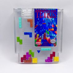 a game that is on display in a plastic case with some colored blocks attached to it