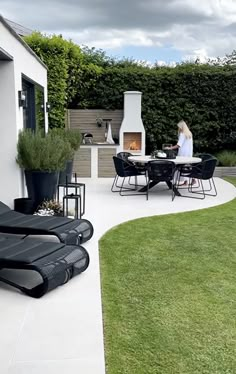 a woman sitting at a table on top of a patio next to a fire place