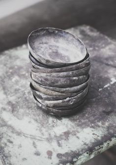 a stack of bowls sitting on top of a stone slab