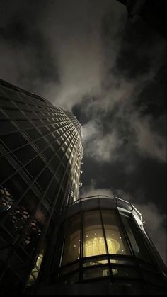 the sky is very dark and cloudy with some buildings lit up at night in the foreground