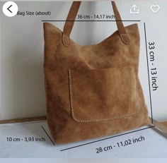 a brown suede bag with white stitching on the side and measurements for it