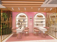 the interior of a nail salon with pink walls and gold trimmings on the ceiling