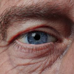 an older man's blue eye is shown in this close - up photo from the side