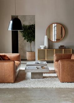 a living room with two couches, a coffee table and a mirror on the wall