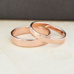 two wedding rings sitting on top of a table