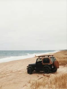 an old jeep is parked on the beach